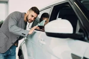 Homme inspectant une voiture d'occasion avant son achat