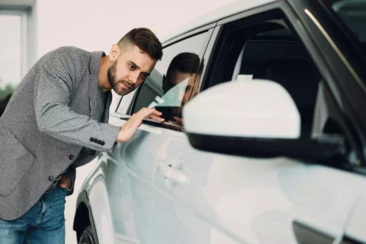 Homme inspectant une voiture d'occasion avant son achat