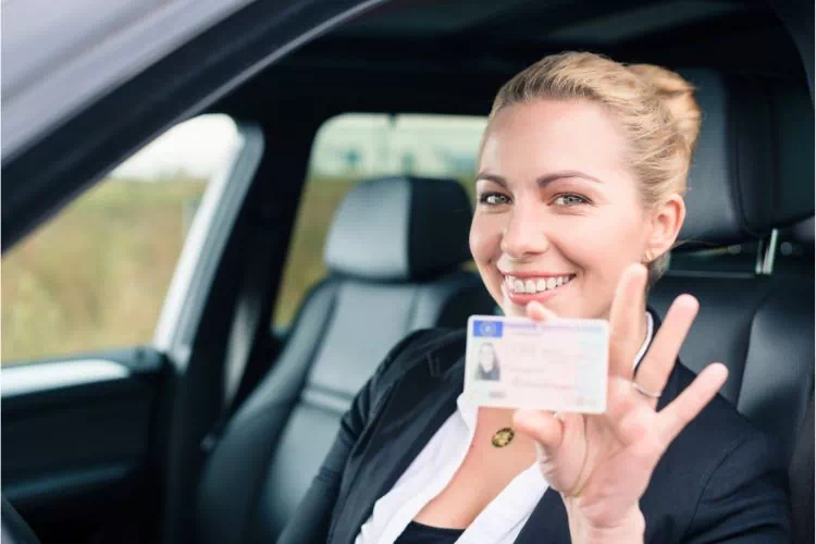 Femme tenant son permis de conduire