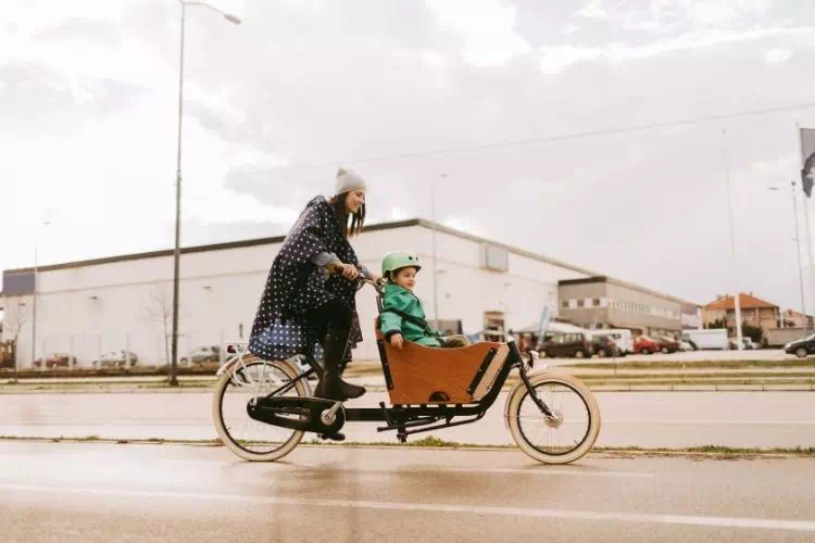 Maman transportant son enfant sur un vélo cargo