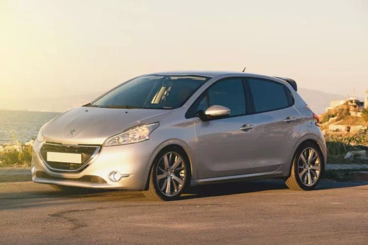 Peugeot 308 grise sur le bord d'une route le long de la mer