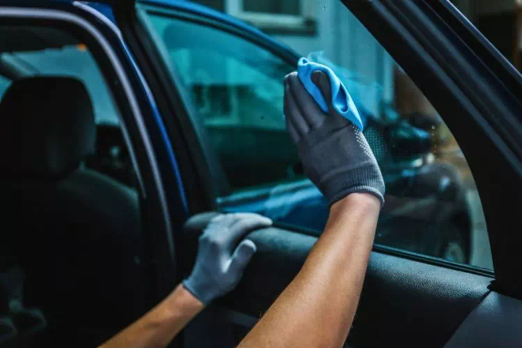 Personne en train de nettoyer une vitre de voiture